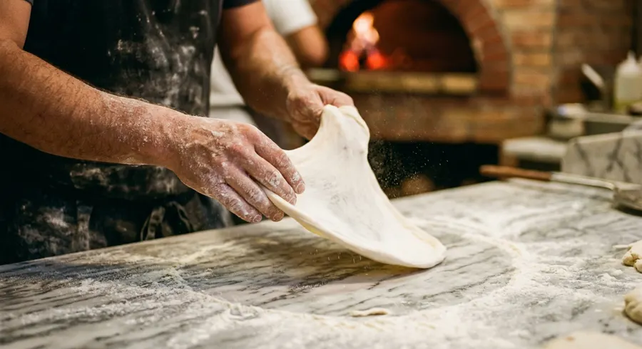 Der Pizzaiolo formt frischen Pizzateig